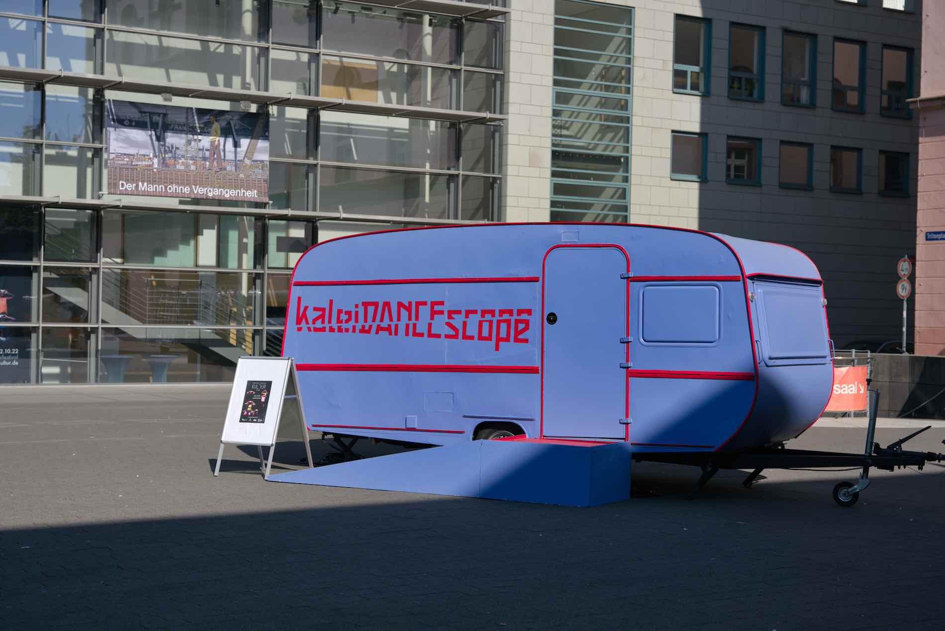 The kaleiDANCEscope trailer stands on the empty Tritonplatz in front of the theater's glass extension, waiting for the show to start.
photo: Cornelius Schaper